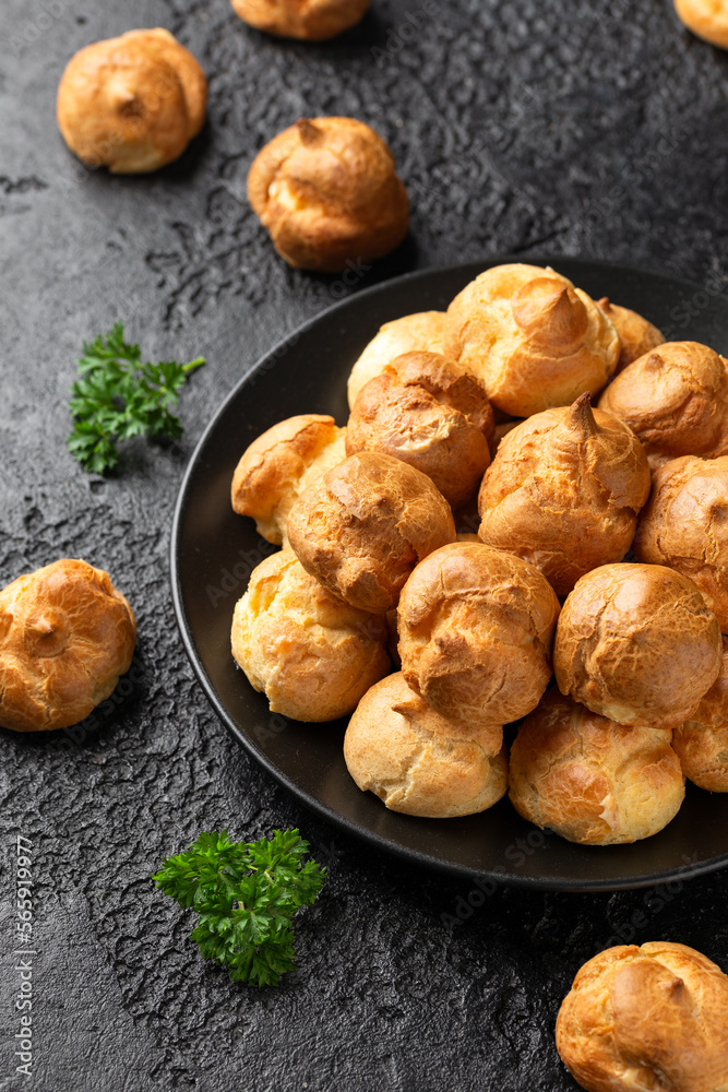 Savoury profiteroles stuffed with Molten cheddar cheese sauce, party food concept