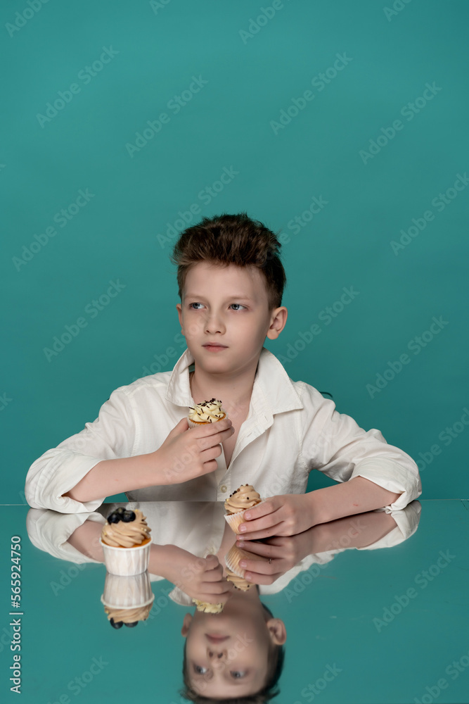 studio portrait of a boy on a blue background with sweets