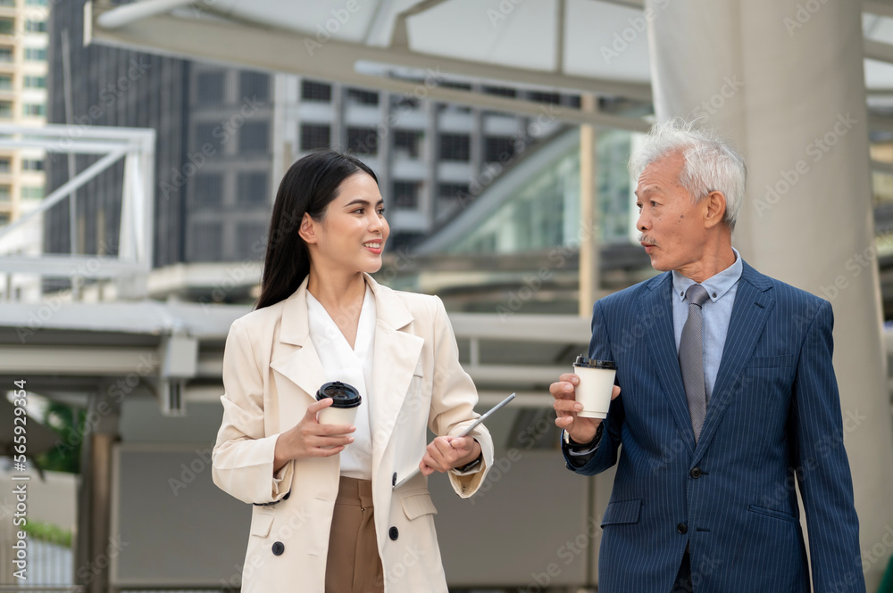 Asian senior mature middle aged businessman and young businesswoman having a discussion and coffee in modern city