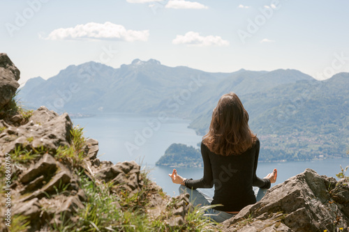 Junge Frau beim Meditieren mit Aussicht auf den Comer See und Berge © Carola Stober