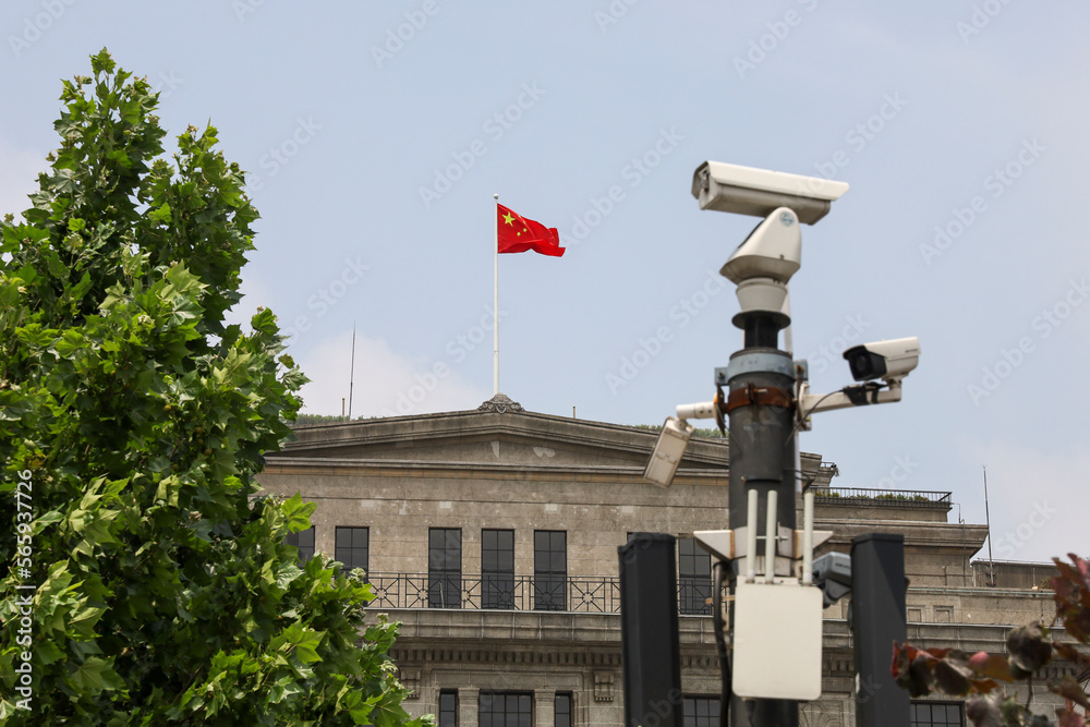 Chinese Flag on top of government building and security tiry camera on the foreground - obrazy, fototapety, plakaty 
