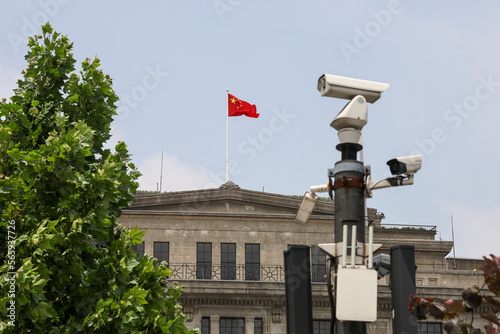 Chinese Flag on top of government building and security tiry camera on the foreground