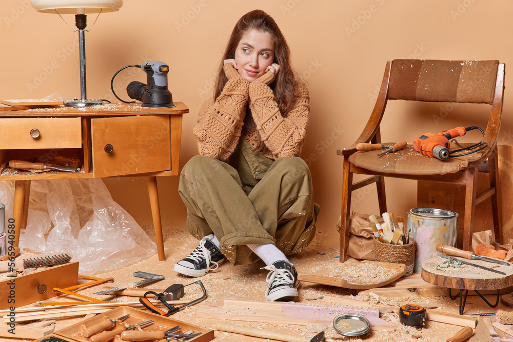 Female woodworker busy repairing wooden furniture works in carpentry