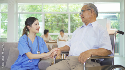 An Asian nurse talking to a group of old elderly patient or pensioner people smiling  relaxing  having fun together in nursing home. Senior lifestyle activity recreation. Retirement. Health care