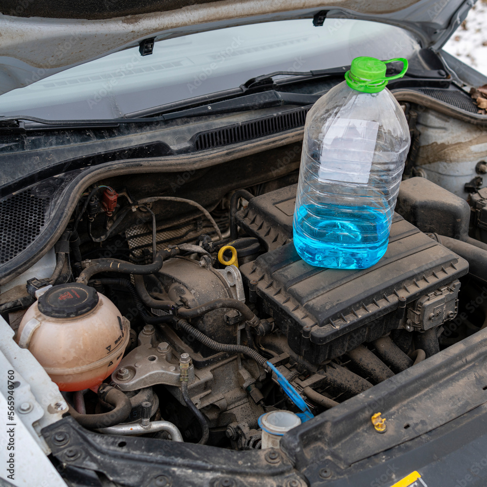 Blue antifreeze windshield washer fluid is on the engine to fill in