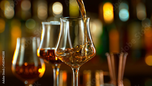 Tableau sur toile Close-up of pouring whiskey or rum in a pub