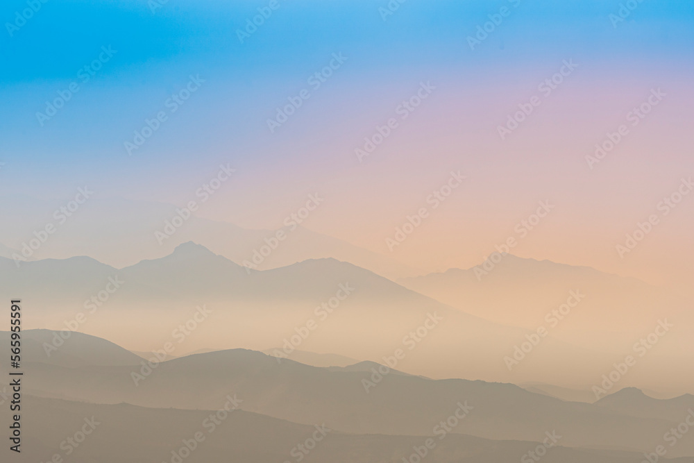 A magical dawn over the Caucasus Mountains with layers of mountain ranges and a blue sky