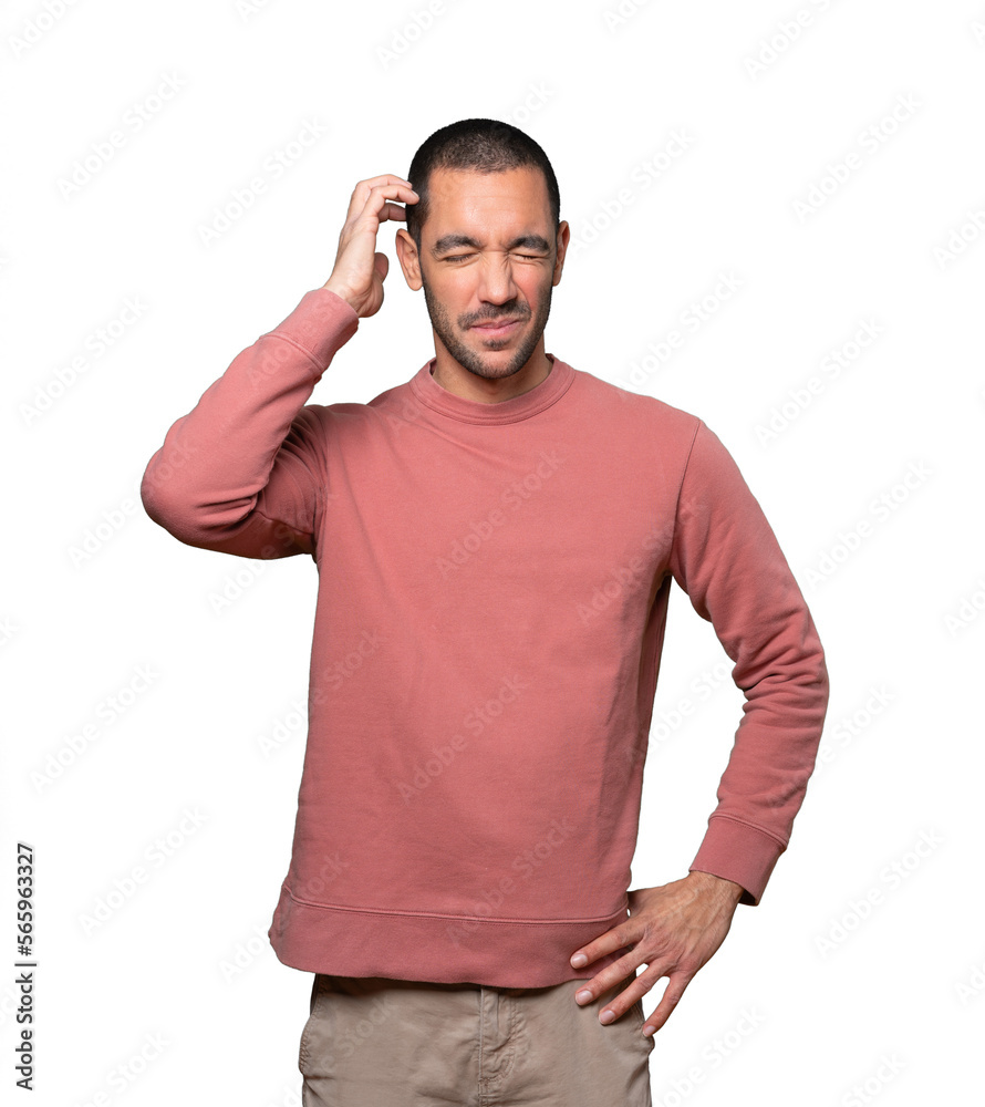 Concerned young man making a scratching gesture Concerned young man making a scratching gesture