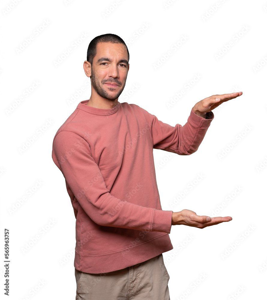 Confident young man doing a gesture of holding something with his hands Confident young man doing a gesture of holding something with his hands