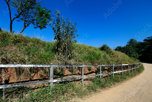 Fototapeta Naklejka Na Ścianę i Meble -  Wooden fence bordering dirt road in countryside of Brazil