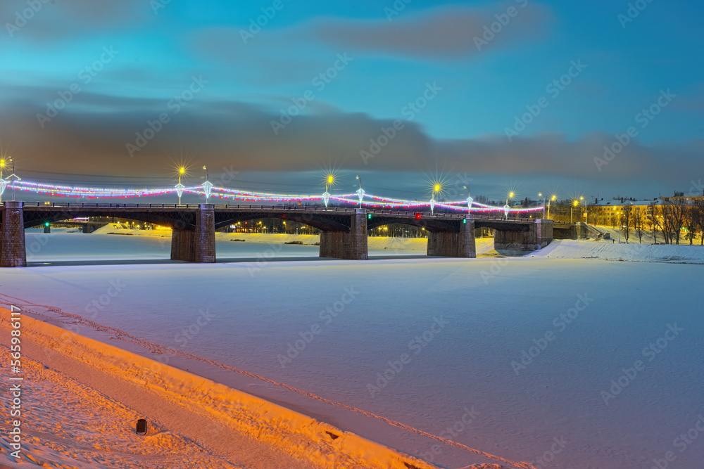 Beautiful evening illumination of the New Volga bridge in the city of Tver. Evening city lights in winter.