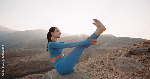 Outdoor yoga practice. Slim Asian woman practicing Ubhaya Padangusthasana, Young athletic girl meditating, doing various yoga poses, training in mountains during sunrise active lifestyle, zen concept  photo