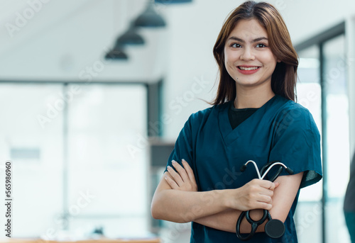 Portrait of young female doctor standing in hospital.