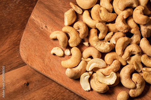 Cashew nuts from above. Close up photo with cashew on a wooden plate. Nuts healthy food and source of protein.