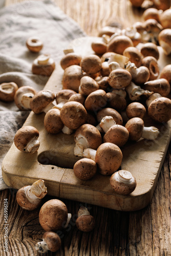 Organic fresh brown mushrooms on a wooden board, close up view