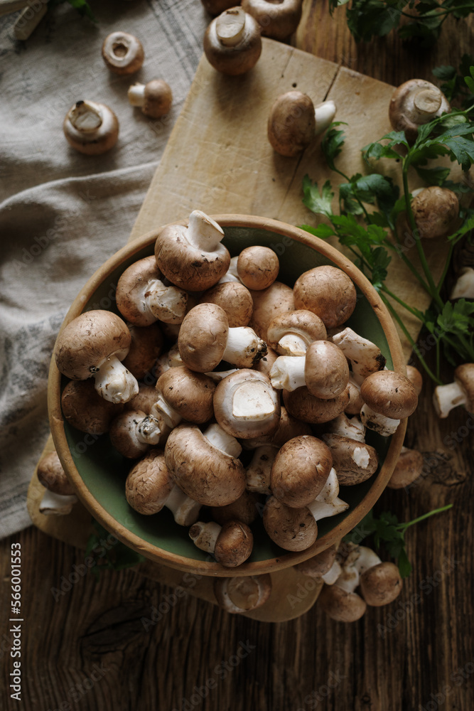 Fresh brown mushrooms in a ceramic rustic bowl, top view. Organic brown champignons Fresh brown mushrooms in a ceramic rustic bowl, top view. Organic brown champignons