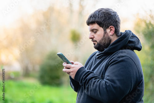 obese young man with hearing impairment  writes a text message