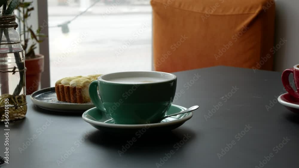 Person sliding a cup with coffee towards him. Cappuccino and latte with a foam on the top in ceramic cups for couple or friends. Coffee morning in the cafe Person sliding a cup with coffee towards him. Cappuccino and latte with a foam on the top in ceramic cups for couple or friends. Coffee morning in the cafe