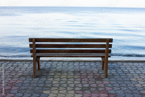 Bench in front of seaside. Wooden bench for watching blue and clean sea. Beach Bench Seat with the beautiful sea and coast view.