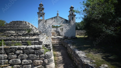 View of historic catholic church showing the original Mayan ruins pyramid to the left. photo