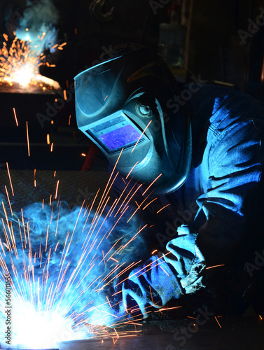Workers wearing industrial uniforms and Welded Iron Mask at Steel welding plants, industrial safety first	

