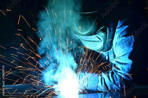 Workers wearing industrial uniforms and Welded Iron Mask at Steel welding plants, industrial safety first	
