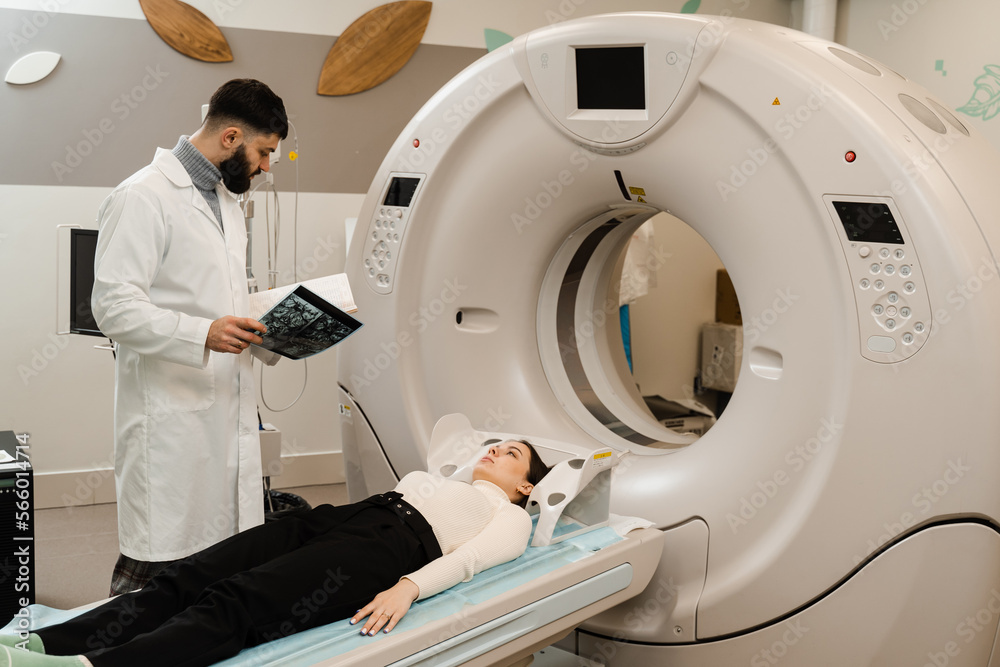 CT scan of brains of woman in medical clinic. Girl patient is doing computed tomography x-ray examination of tumor in his head in a CT scan room. CT scan of brains of woman in medical clinic. Girl patient is doing computed tomography x-ray examination of tumor in his head in a CT scan room.