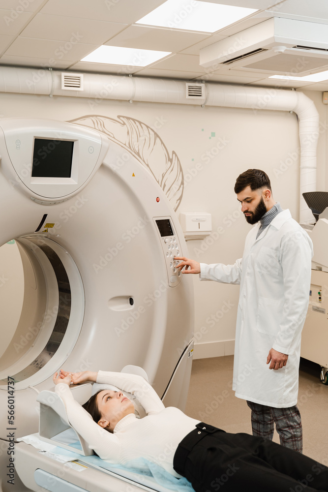 CT scan of abdomen of woman in medical clinic. Girl patient is doing CT computed tomography x-ray scan of chest for examination of abdomen in a CT scanning room. CT scan of abdomen of woman in medical clinic. Girl patient is doing CT computed tomography x-ray scan of chest for examination of abdomen in a CT scanning room.