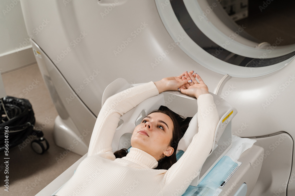 CT x-ray examination of lung cancer in medical clinic. Patient girl lies on computed tomography bed and scanning lungs for diagnose lung cancer in medical clinic. CT x-ray examination of lung cancer in medical clinic. Patient girl lies on computed tomography bed and scanning lungs for diagnose lung cancer in medical clinic.