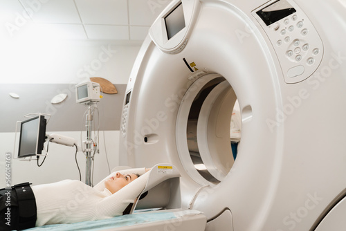 CT x-ray examination of lung cancer in medical clinic. Patient girl lies on computed tomography bed and scanning lungs for diagnose lung cancer in medical clinic.