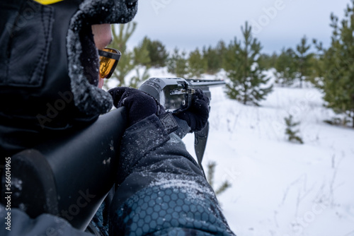 Hunter with a gun in the winter forest
