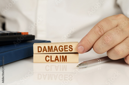 Фотография In the hands of a businessman, wooden blocks with the inscription - Damages Clai