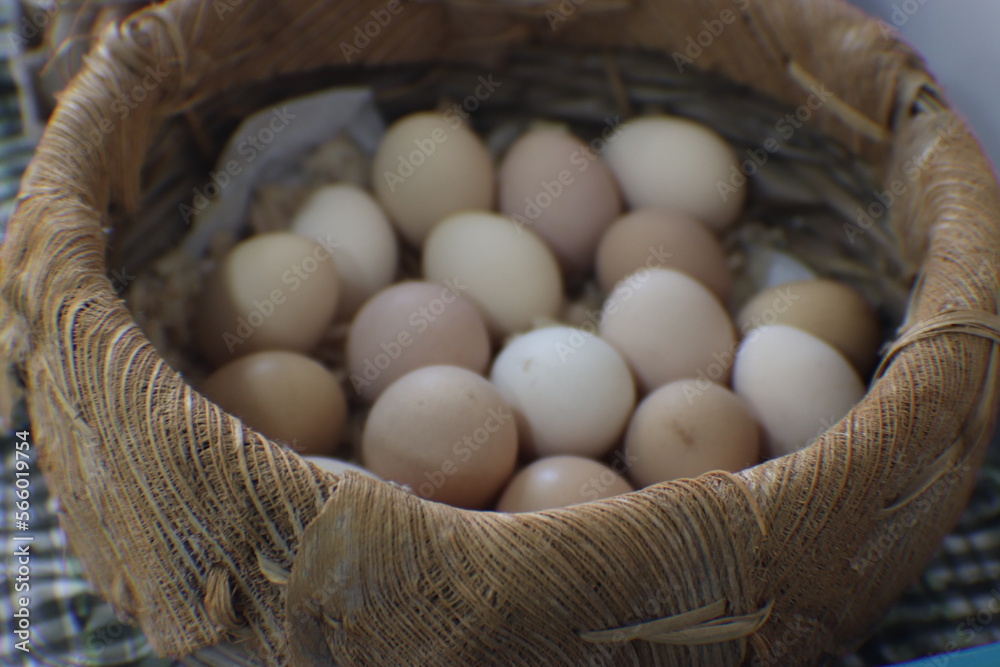 Fresh chicken eggs arranged in a wicker basket.