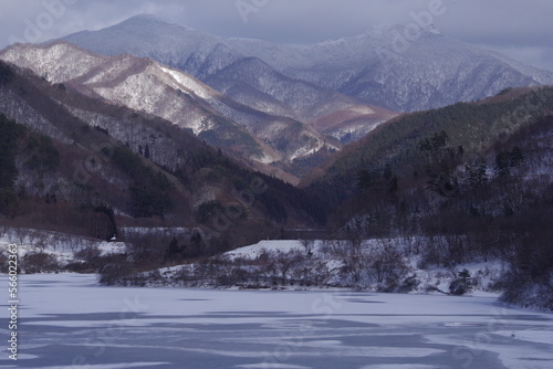 Winter lake and mountain snow scene. Winter afternoon landscape photo.