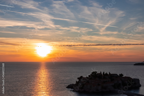 Panoramic sunset view at Adriatic Mediterranean Sea near Sveti Stefan, Budva Riviera, Montenegro, Europe. Reflection of sun beams on water surface during twilight. Summer vacation in seaside resort © Chris