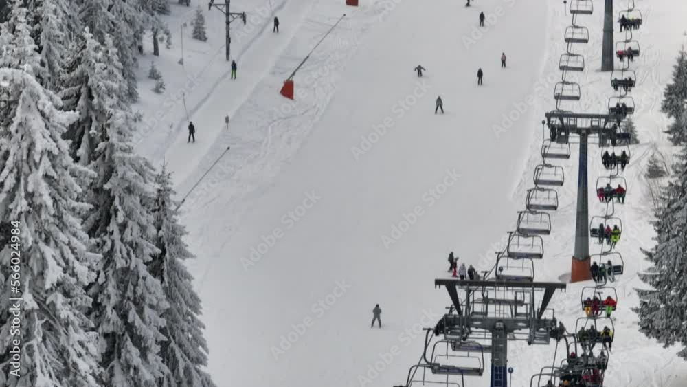 Lift cabins in a mountain ski resort and people skiing on snow mountain Lift cabins in a mountain ski resort and people skiing on snow mountain