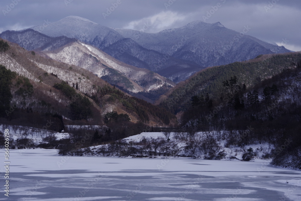 Winter lake and mountain snow scene. Winter afternoon landscape photo.