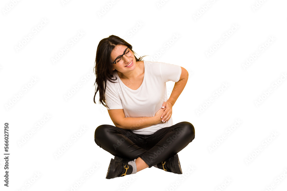 Young indian woman sitting on the floor cut out isolated having a liver pain, stomach ache. Young indian woman sitting on the floor cut out isolated having a liver pain, stomach ache.