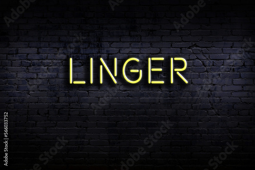 Foto Neon sign. Word linger against brick wall. Night view