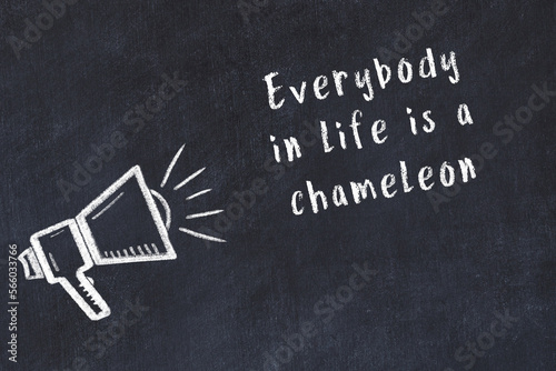 Chalk loudspeaker and wise quote on black desk