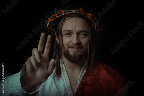 Jesus Christ wearing a crown of thorns and white chiton toga mantle cape himation suffering for mankind's sins in artistic mystical portrait photo
