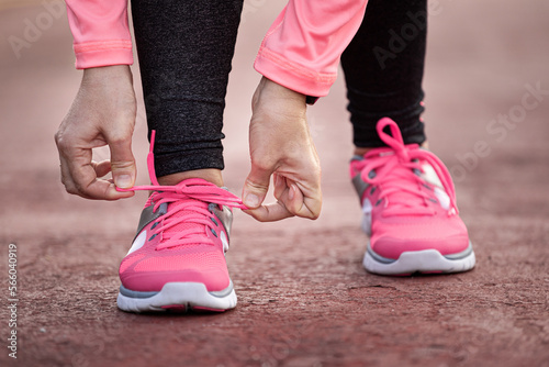 Runner woman tying up laces of shoes, getting ready to run for cardio and weight loss