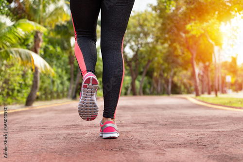 Fototapeta Naklejka Na Ścianę i Meble -  Fitness woman training and jogging in summer park, close up on running shoes