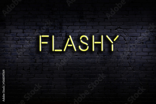 Neon sign. Word flashy against brick wall. Night view photo