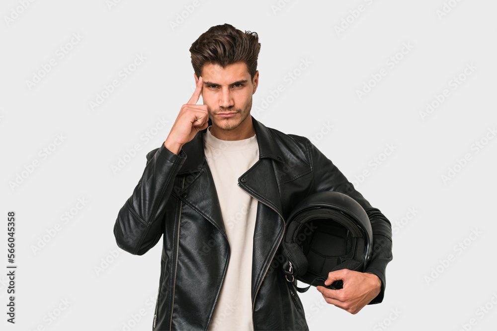 Young caucasian man holding a motrbike black helmet isolated pointing temple with finger, thinking, focused on a task. Young caucasian man holding a motrbike black helmet isolated pointing temple with finger, thinking, focused on a task.
