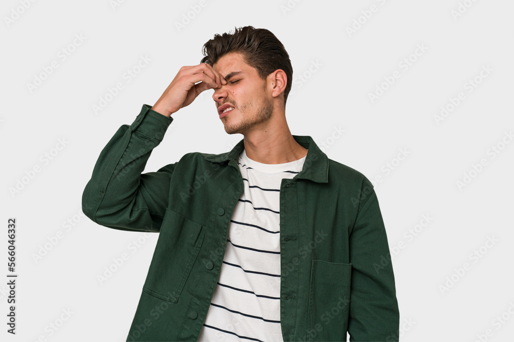 Young handsome caucasian man isolated on white background having a head ache, touching front of the face. Young handsome caucasian man isolated on white background having a head ache, touching front of the face.
