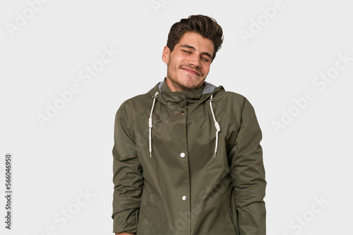 Young handsome caucasian man isolated on white background laughs and closes eyes, feels relaxed and happy.