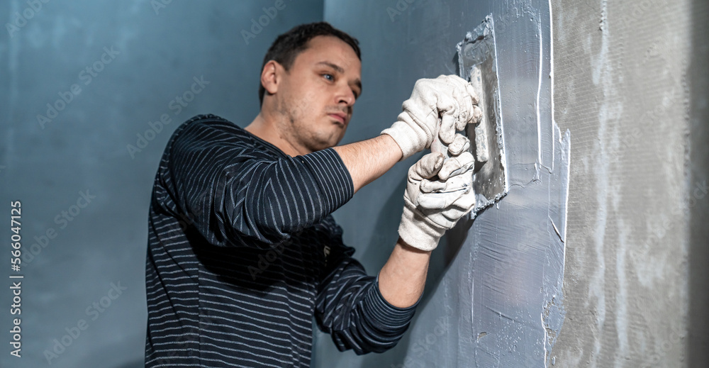 man applies insulation to a bathroom wall