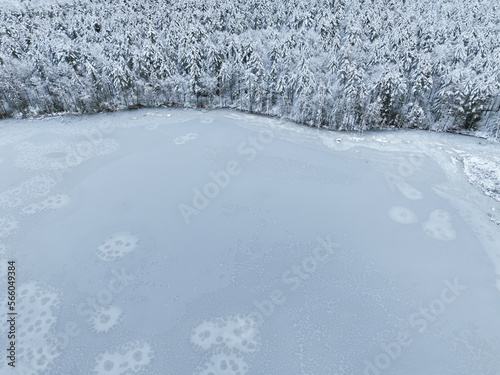 aerial view of frozen lake in winter after snow with forest