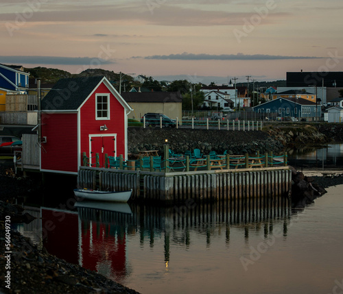 Red fishing shack reflecting in the water in Twillingate Newfoundland